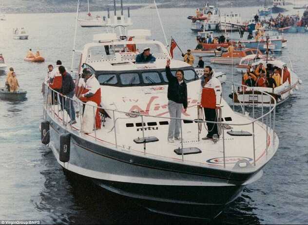 Richard Branson winkt an Bord seines Rekord-Schnellboots Virgin Atlantic Challenger, umringt von einer Flotte begleitender Boote im Hafen